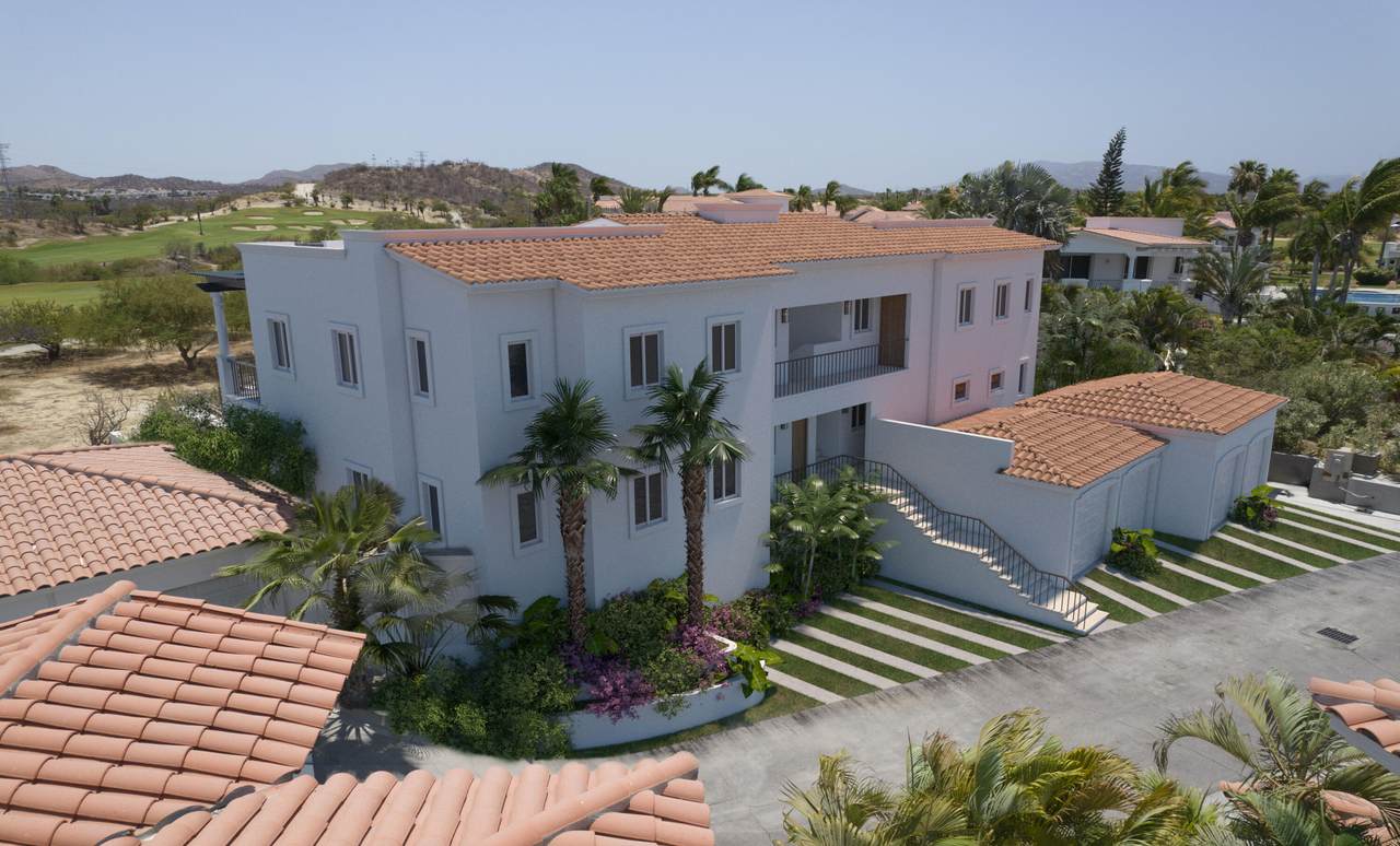 A Building With Palm Trees And A Road