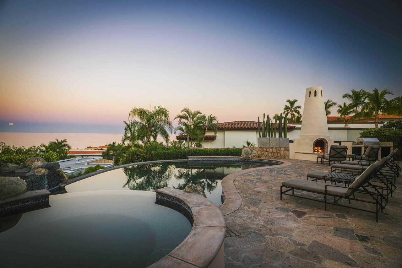 A Pool With Chairs And A Fireplace