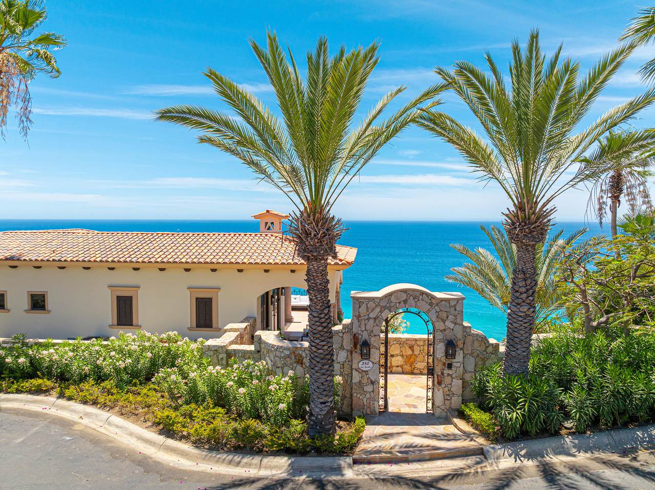 A House With Palm Trees And A Stone Wall